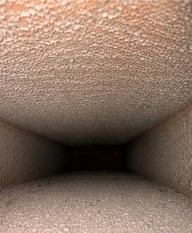 Inside a lined duct before cleaning: the liner coated grey with dust