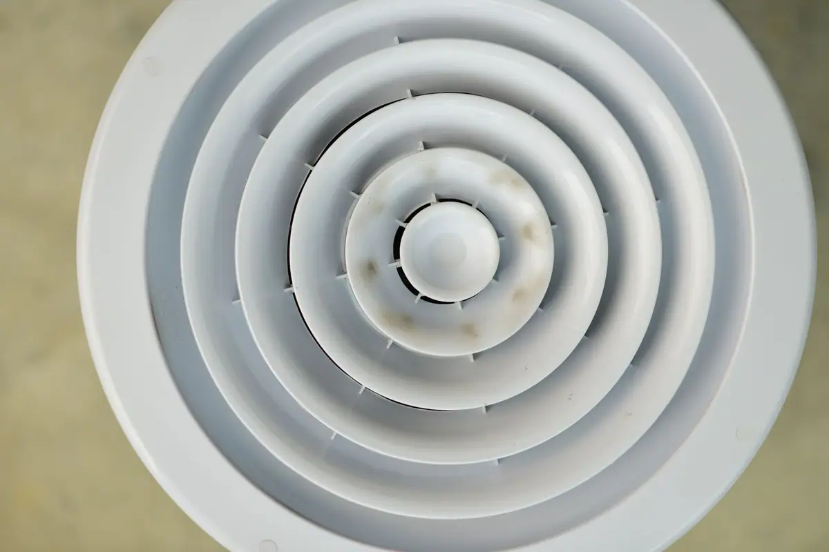 Round ceiling diffuser with a ring of dust staining around it