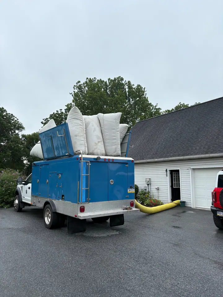 The Dirty Ductz truck on a job, collection bags on the roof and the hose running into the garage